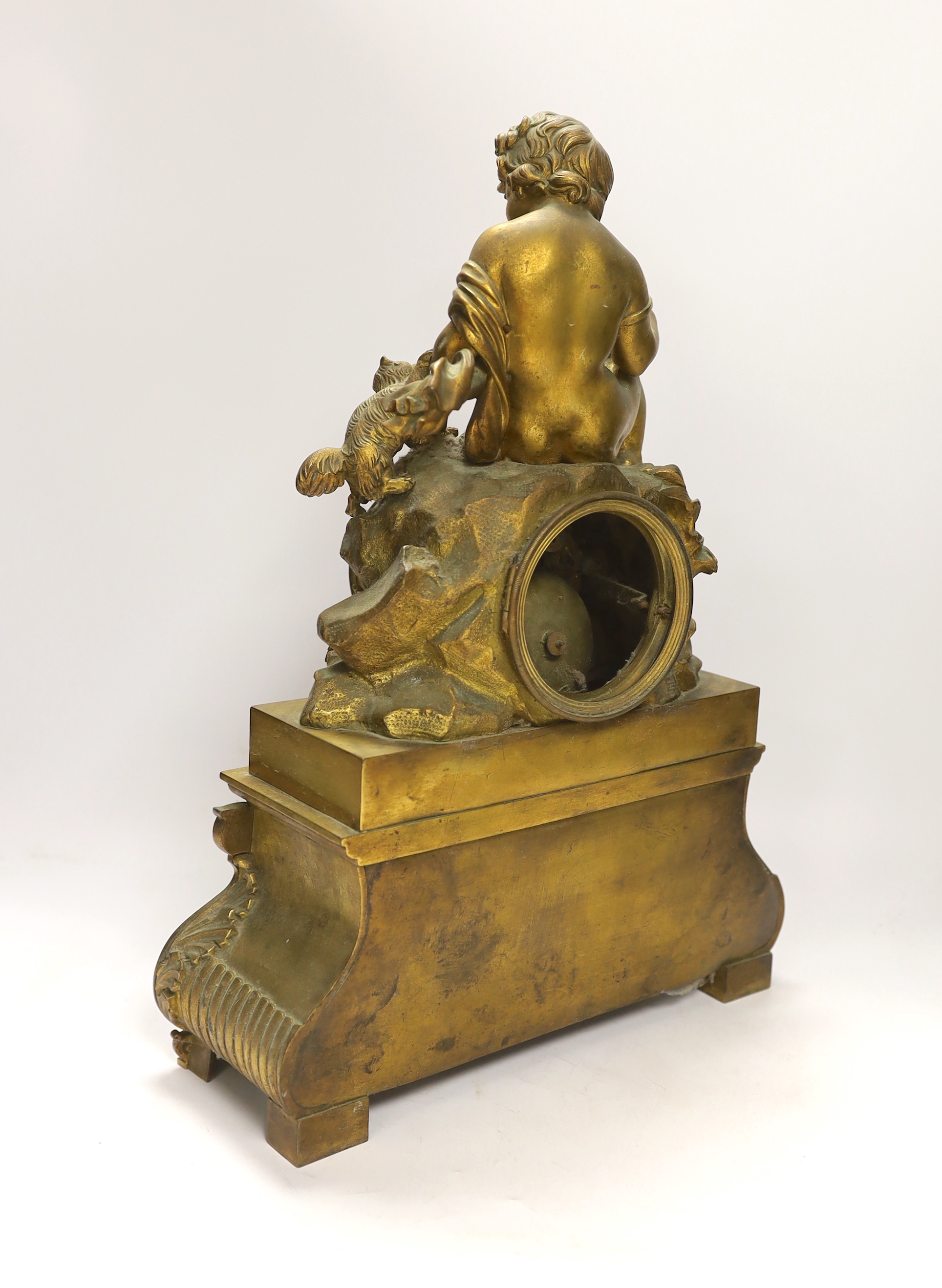 A decorative French ormolu mantel clock, the top a child playing with a kitten and the base with scrolled feet below a swag of flowers, 42cm high